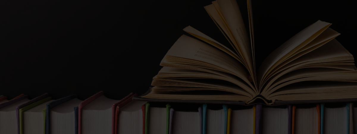 A row of books with an open book sitting on top.