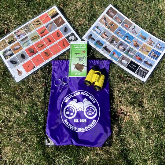 A Wetland Edu-Kit in a purple bag on grass.