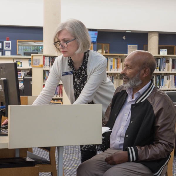 Library staff member helps a man image