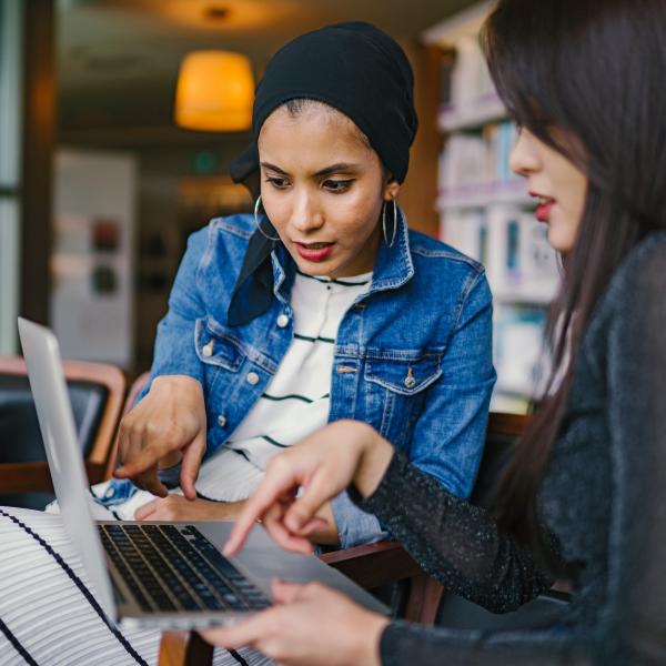 Two people looking at a laptop. 